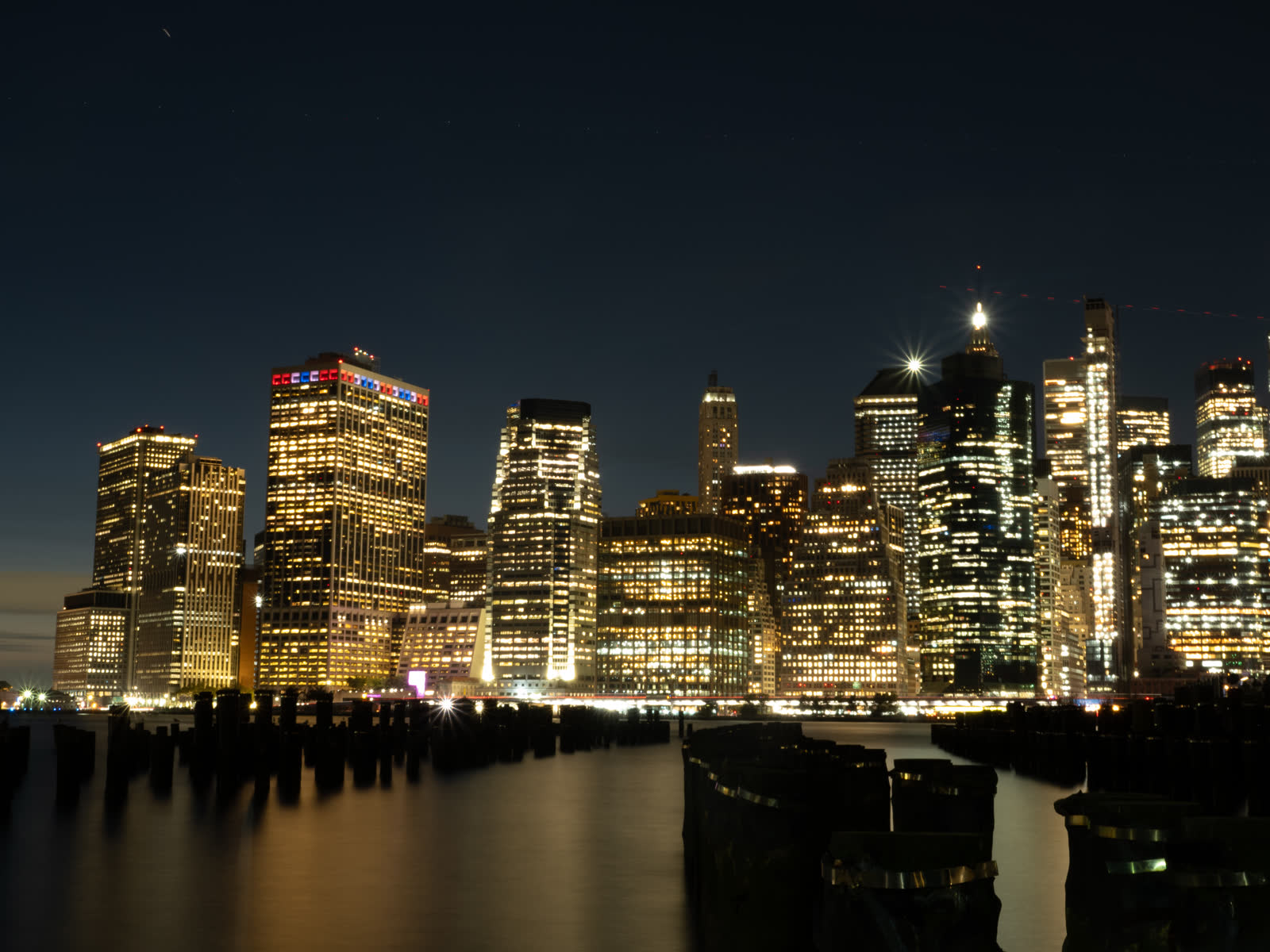 Skyline von Manhattan bei Nacht mit alten Hafenpfählen — Martina Ziegler